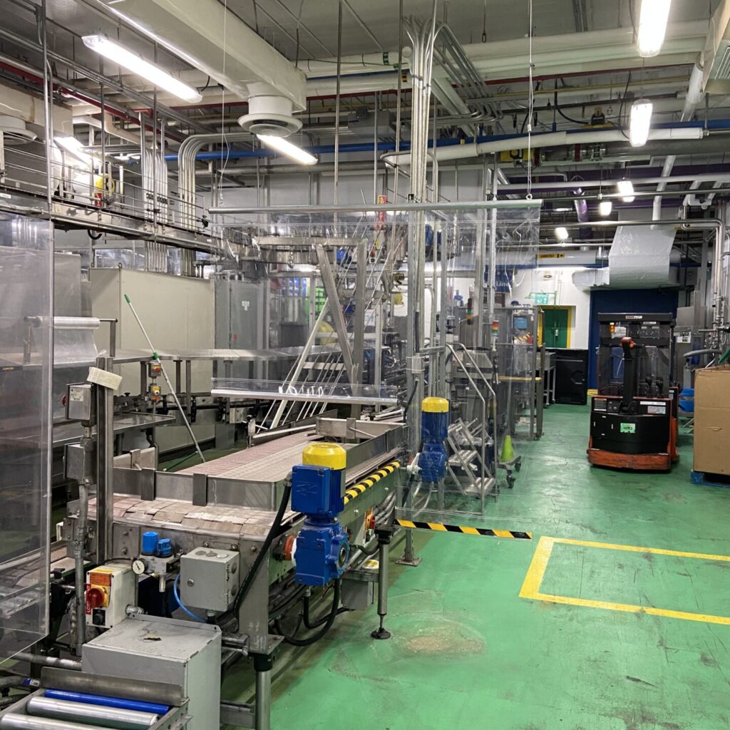 A bustling factory floor features a production line with conveyor belts and machinery dedicated to manufacturing COVID separators at shomi!